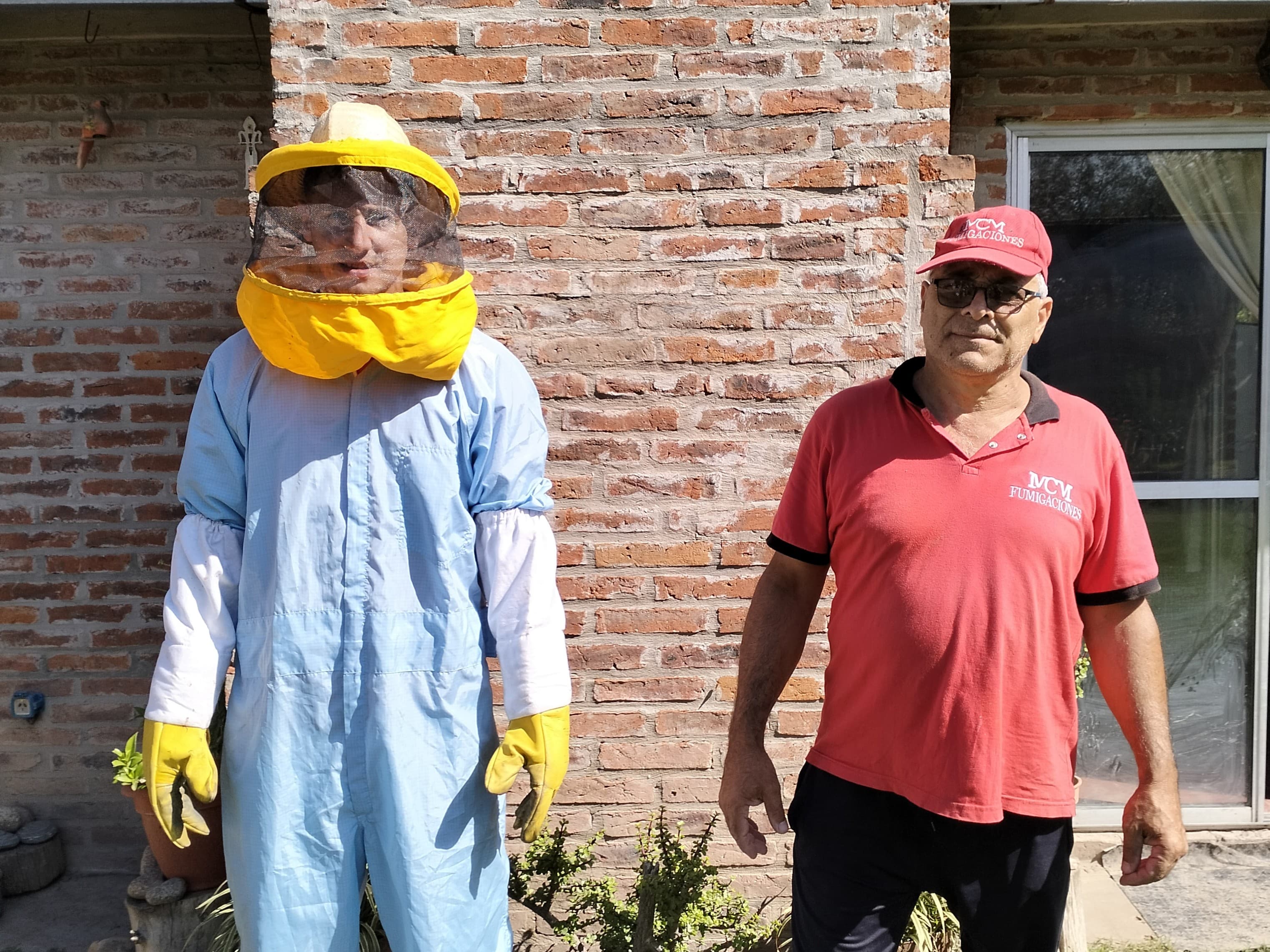 Personal con traje de apicultor y uniforme